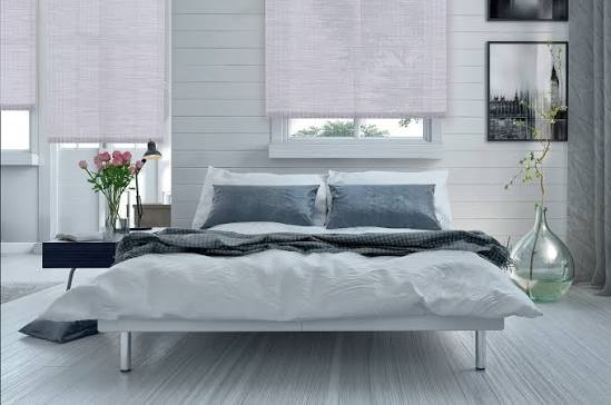 Custom roller shades in a bright bedroom